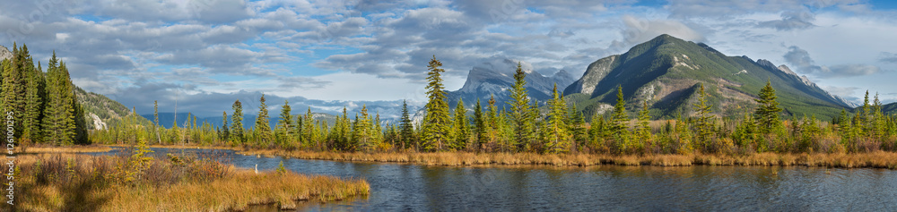 A stunning view of Vermillion Lake with Mount Rundle in the background. The calm water, autumn colors, evergreen trees, and snow-capped peaks create a breathtaking and serene natural landscape. A stunning view of Vermillion Lake with Mount Rundle in the background. The calm water, autumn colors, evergreen trees, and snow-capped peaks create a breathtaking and serene natural landscape.