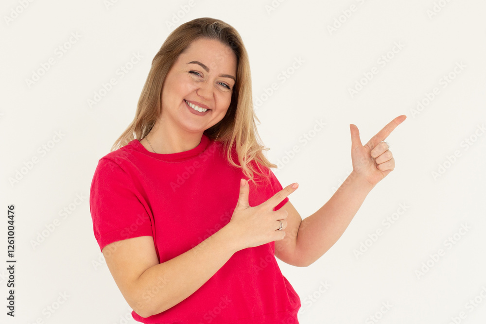 Hey look. Smiling pretty female model pointing fingers right at empty space and inviting to check it out, showing advertisement on white background. Hey look. Smiling pretty female model pointing fingers right at empty space and inviting to check it out, showing advertisement on white background.