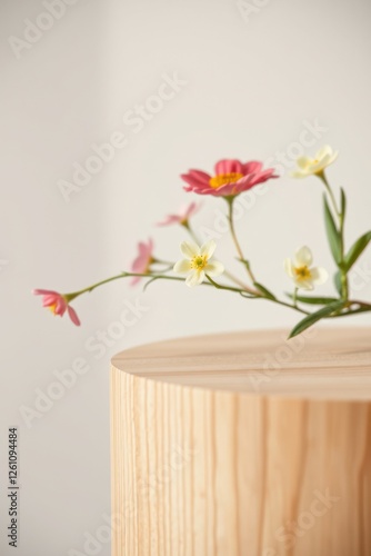 Floral arrangement of pink and white flowers on a wooden pedestal. Soft lighting and minimalist style.