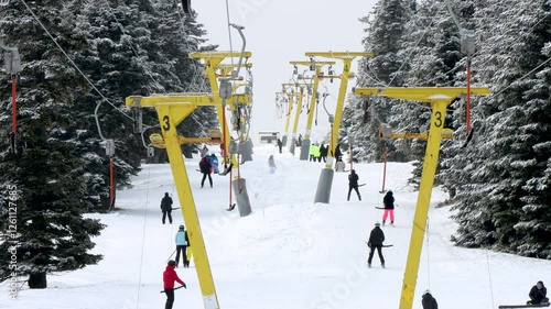 Peoples going out for skiing with chairlift in snowy winter mountain ski resort. Snow holiday concept