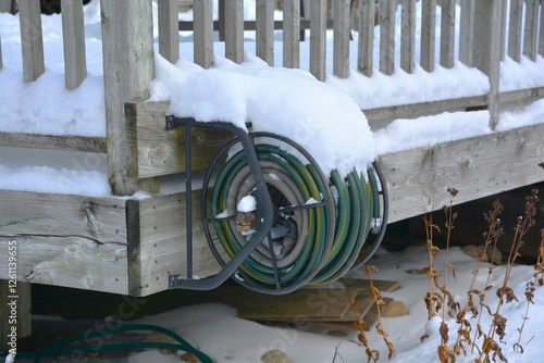Obraz na plátně Snow builds up on an outside garden hose and reel during a Canadian winter