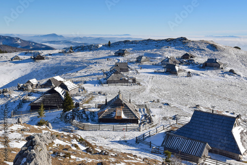 Pasture plateau Mala Planina at Kamnik Savinja Alps with wooden cottages photo