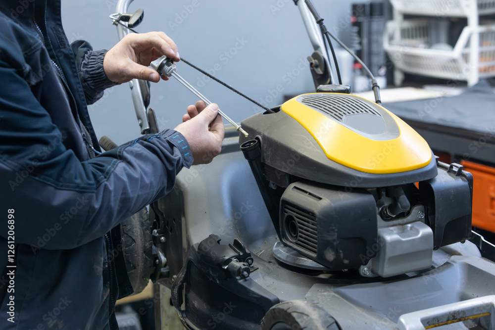 man checking the oil on a lawnmower man checking the oil on a lawnmower