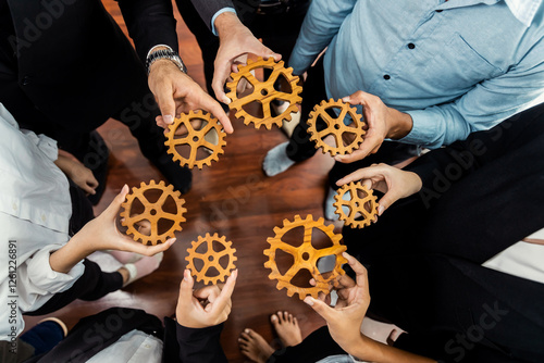 Group of multiracial business people joining gear wheels together as effective unity and productive teamwork concept. Efficient system business team process for solution solving. Meticulous