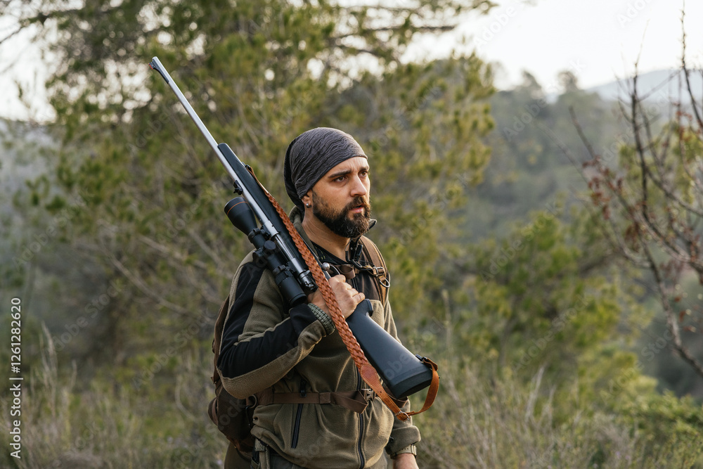 Hunter walking in the woods carrying hunting rifle Hunter walking in the woods carrying hunting rifle