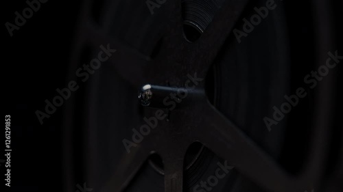 Close ups of a vintage 8MM projector spools moving and playing film 