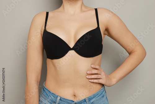 Woman wearing beautiful bra on light background, closeup photo