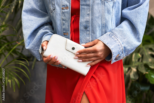 Obraz na płótnie Elegant woman in denim jacket and red dress holding stylish white wallet outdoors, fashion and lifestyle concept w salonie
