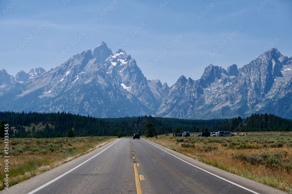 Scenic road in Grand Teton National Park with a view of the mountains and forest. Scenic road in Grand Teton National Park with a view of the mountains and forest.