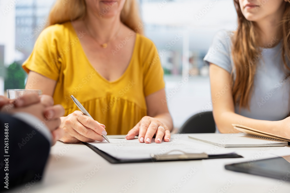 Fototapeta premium Clients completing forms, taking loan from financial agent, doing handshake after completing deal. Mother and daughter signing contract, entering agreement with financial consultant, close up shot