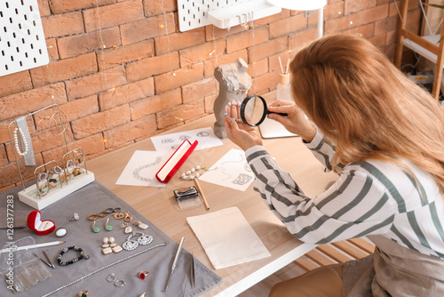 Female jeweler examining br...