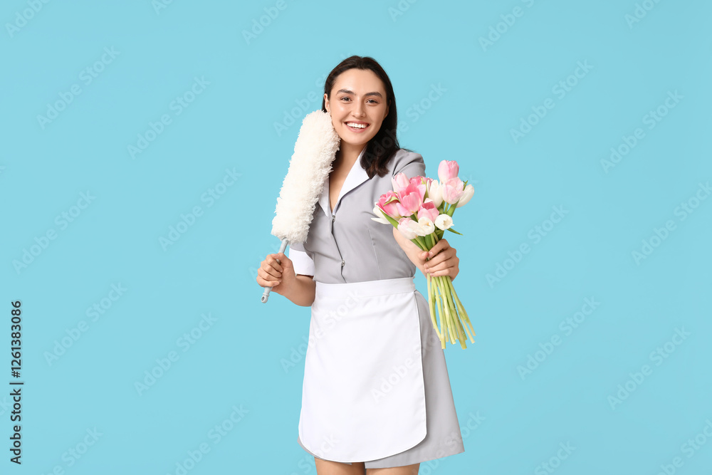 Portrait of young female janitor with bouquet of flowers and pp-duster on blue background. International Women's Day Portrait of young female janitor with bouquet of flowers and pp-duster on blue background. International Women's Day