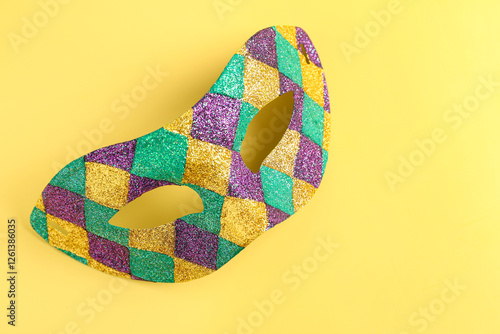 Shiny carnival mask for Mardi Gras celebration on yellow background photo