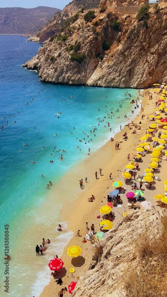 Antalya, August 2024: People sunbathe and swim on Kaputas beach in Turkey on the Mediterranean coast. A beach with clear turquoise waters of the sea, between the towns of Kash and Kalkan. 4K