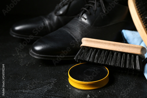 Brushes, shoes, cloth and shoe polish on black background photo