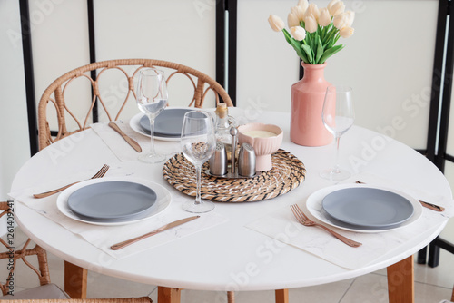 Table setting with tulips near folding screen in room photo