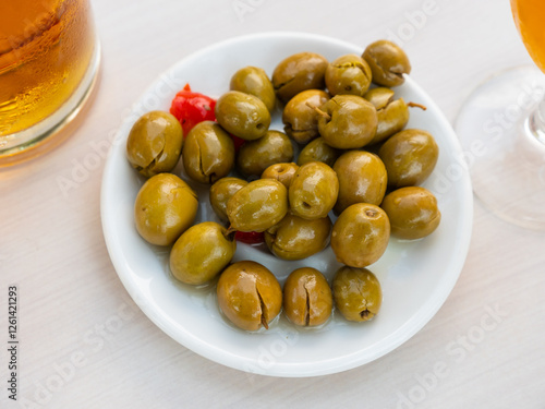 Typical Spanish tapas - appetizing pickled green olives with a stone photo