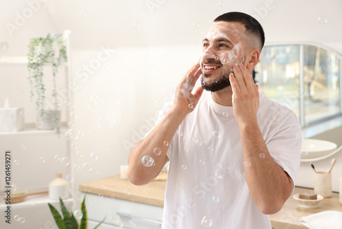 Young man washing his face ...