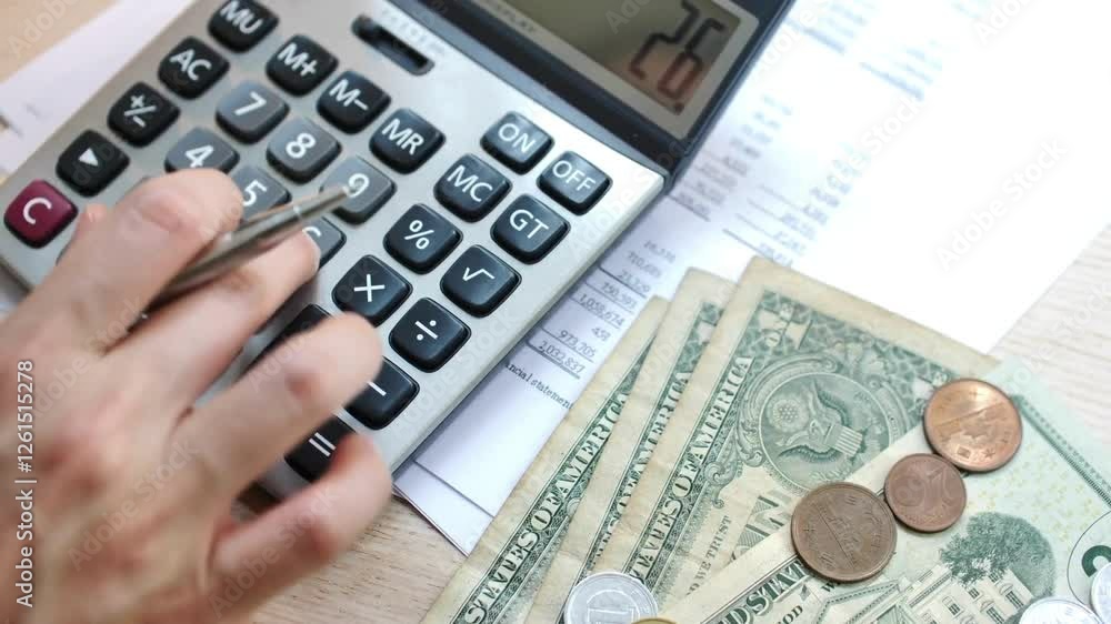 Focused businessman accountant doing calculation for online financial report at workplace. Serious man using calculator paying bill online holding Focused businessman accountant doing calculation for online financial report at workplace. Serious man using calculator paying bill online holding