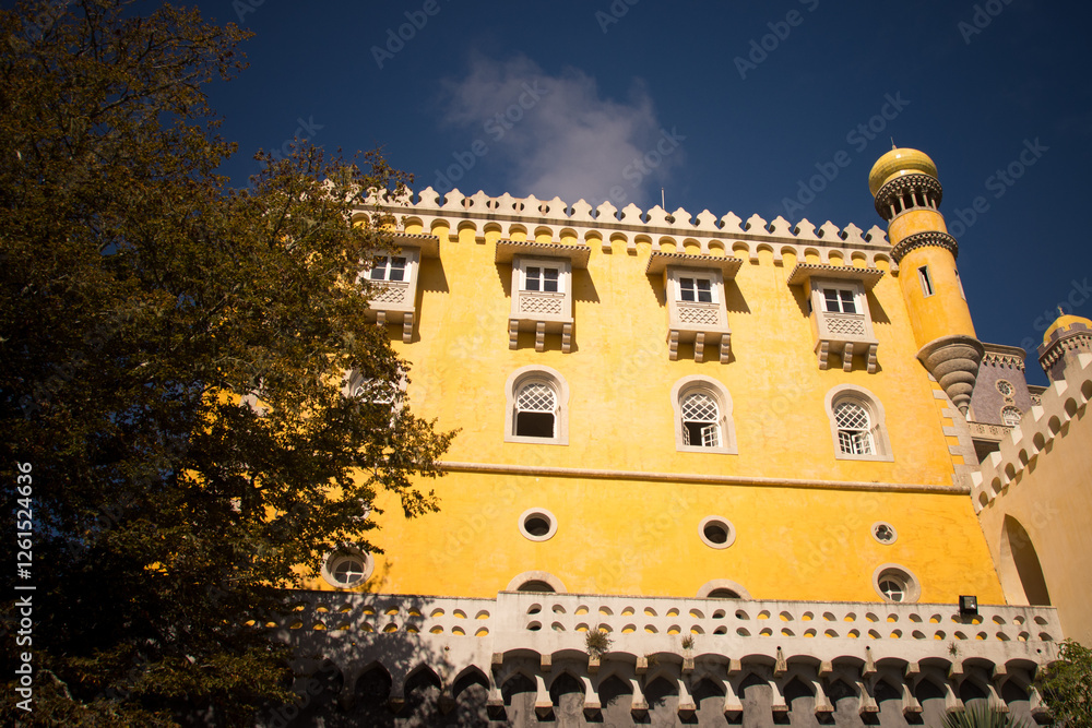 Obraz premium Pena Palace towers with red and yellow facade under blue sky.
