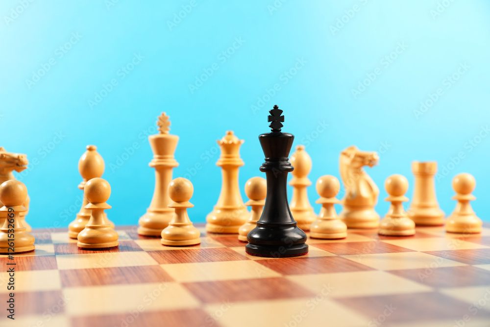 Black king in front of other white chess pieces on chessboard. Competition concept Black king in front of other white chess pieces on chessboard. Competition concept
