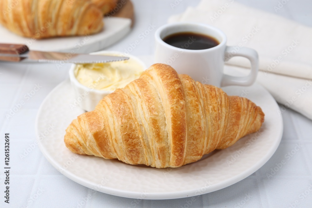 Tasty fresh croissant served with butter and cup of coffee on white tiled table, closeup Tasty fresh croissant served with butter and cup of coffee on white tiled table, closeup