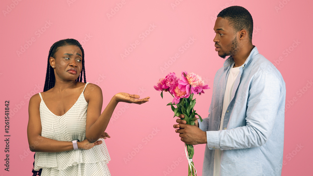 Portrait of African American man giving pretty unhappy bored lady bunch of ugly cheap flowers. Young boyfriend holding present for his ungrateful girlfriend isolated on pink studio background Portrait of African American man giving pretty unhappy bored lady bunch of ugly cheap flowers. Young boyfriend holding present for his ungrateful girlfriend isolated on pink studio background