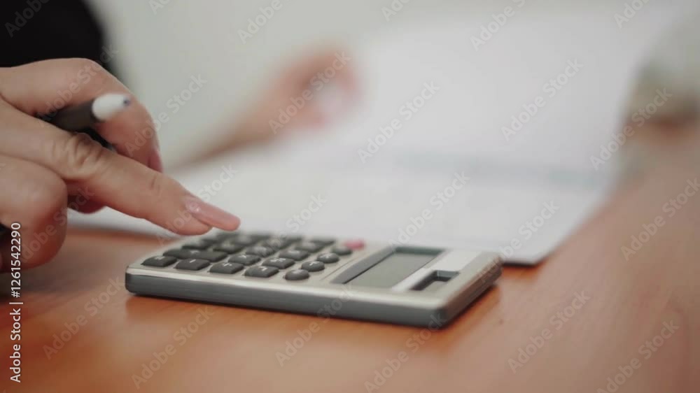 A woman counts money in dollars using a calculator. Family budget financial accounting concept. A woman counts money in dollars using a calculator. Family budget financial accounting concept.