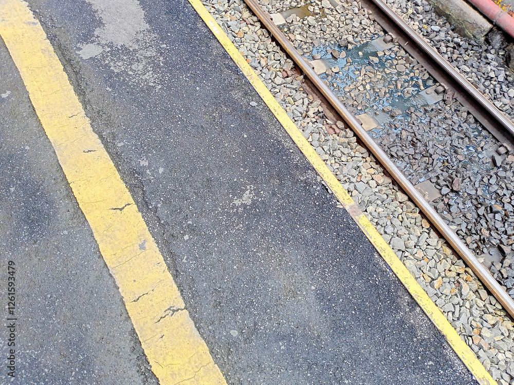 Fototapeta premium Urban Street Scene With Railroad Tracks And Yellow Markings