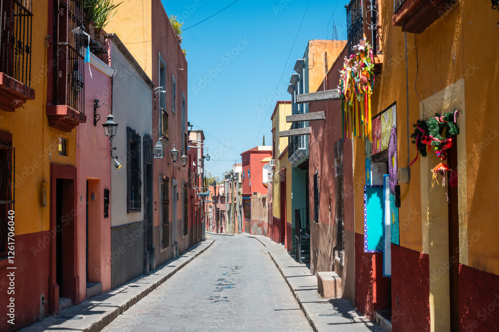 Fototapeta premium Colorful Colonial Street and Road of San Miguel de Allende Mexico. Mexican streets with colorful houses of all colors in the sunshine