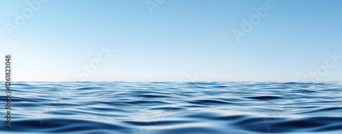 Calm blue ocean water with gentle waves under clear sky