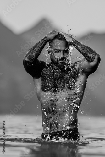 Sexy summer man. Wet muscular male body in water. Nude sexy male body. Man splash in water in summer nature. Fit man posing by summer beach. Strong man splashing in a mountain lake. Summer trip. photo