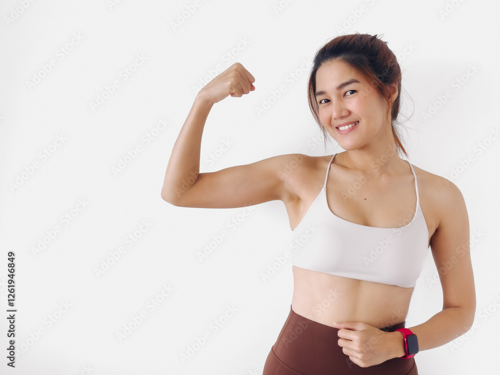 Asian Thai woman wear white sport bras, happy confidence showing strong arm muscle, smiling while standing isolated over white background wall.