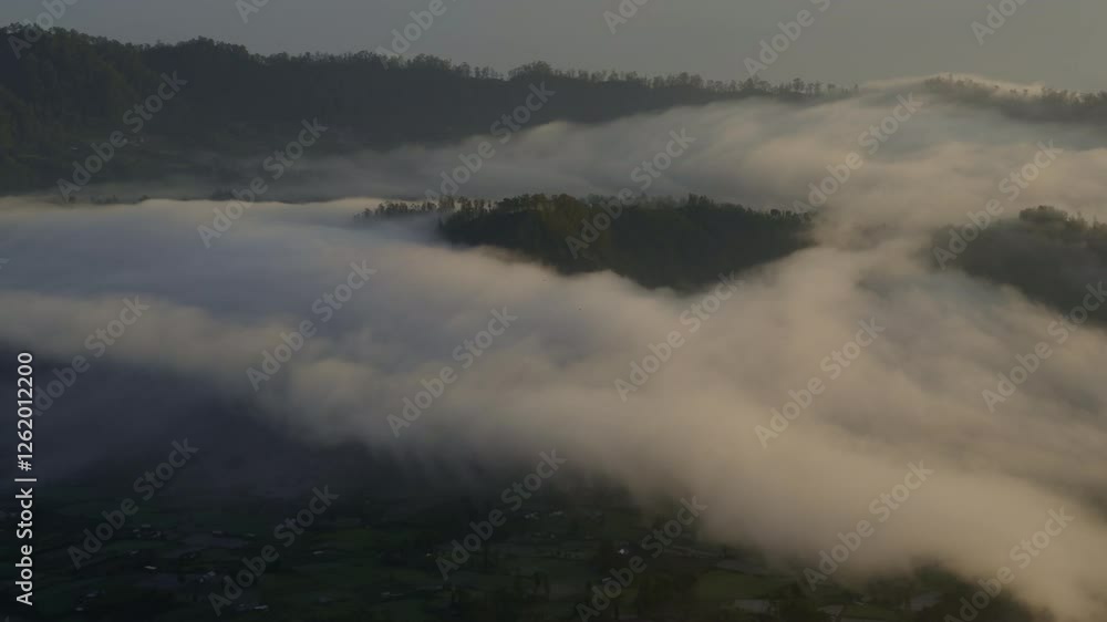 Dramatic Sunrise Over Mount Batur and Village
A stunning aerial view of the volcano and valley, with dramatic clouds partially blocking the glowing sunrise Dramatic Sunrise Over Mount Batur and Village
A stunning aerial view of the volcano and valley, with dramatic clouds partially blocking the glowing sunrise