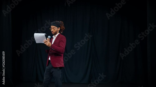 Medium portrait of mixed race male host of event, handsome joyful man speaking. Open mic night in nightclubs or pub, beginner comedian rehearsing performance, african american ethnicity, diversity photo