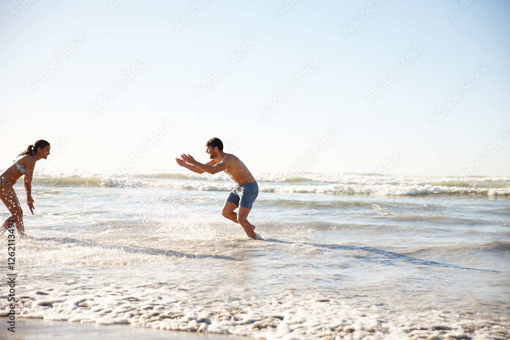 Love, beach play and couple together with splash, vacation and date by sea for romance and affection. Happy man, woman and smile with ocean, summer holiday and fun bonding for honeymoon adventure Love, beach play and couple together with splash, vacation and date by sea for romance and affection. Happy man, woman and smile with ocean, summer holiday and fun bonding for honeymoon adventure