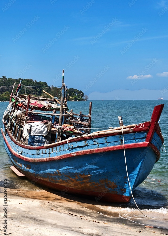 Weathered Wooden Fishing Boat Resting on a Sandy Shoreline Weathered Wooden Fishing Boat Resting on a Sandy Shoreline