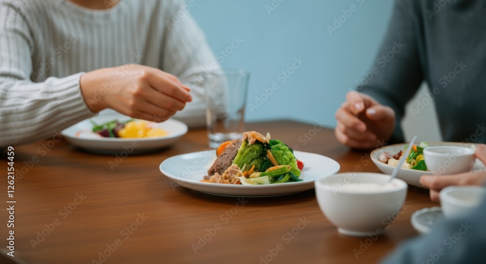 Friends dining together sharing a healthy meal at a table Friends dining together sharing a healthy meal at a table