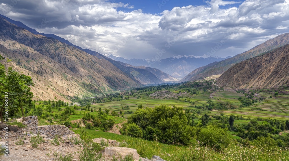 Naklejka premium Mountain valley vista, lush greenery, farming fields, dramatic clouds