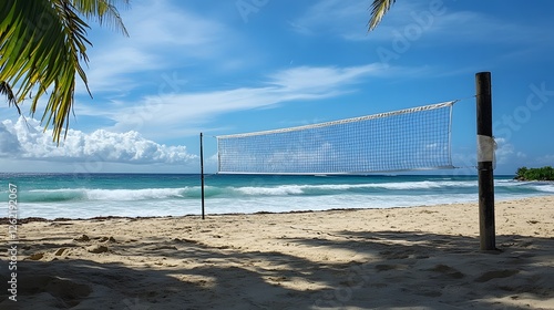 77. A volleyball net set up on a tropical beach with the ocean waves crashing nearby photo