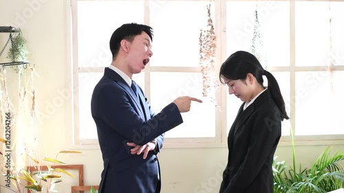 会社でビジネスパーソンの男性が女性に怒る