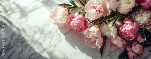 A bouquet of pink and white flowers is arranged on a marble countertop