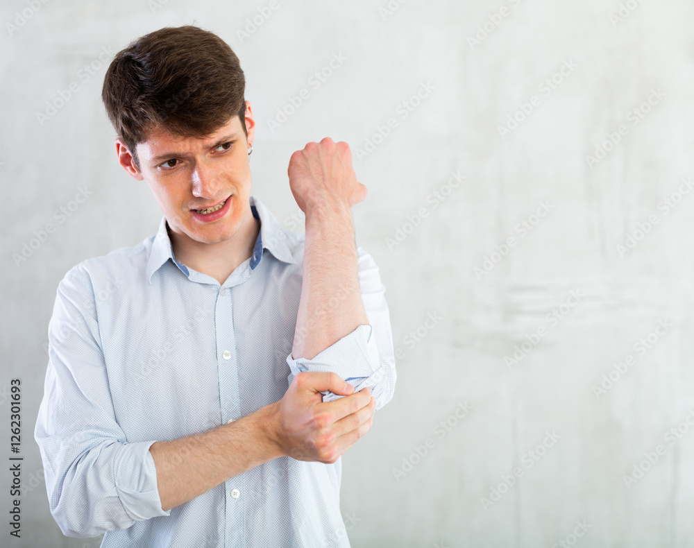 Young guy holding on to sore elbow Young guy holding on to sore elbow