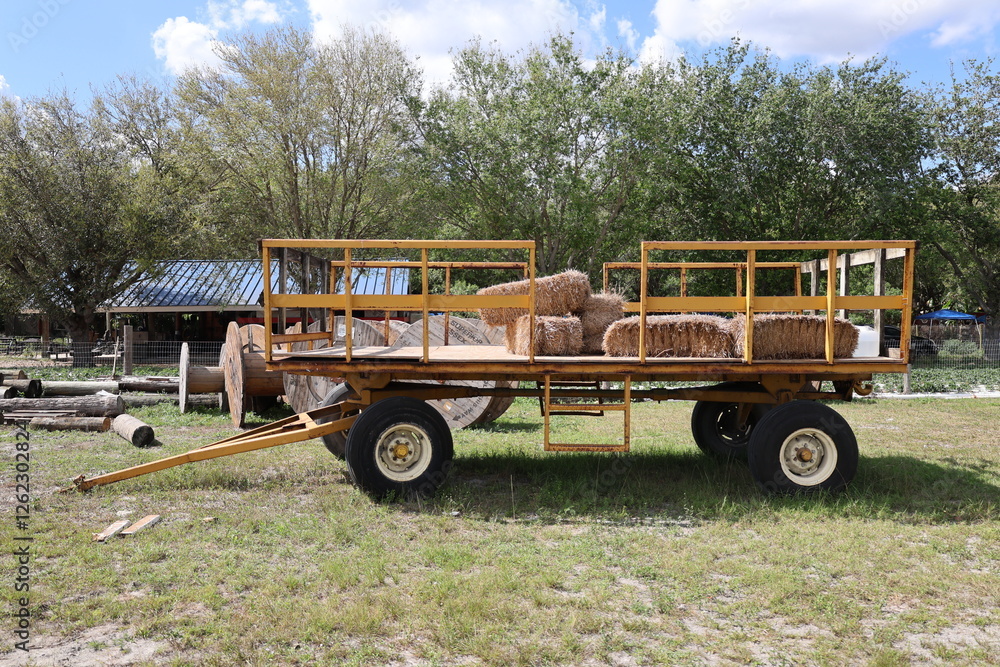 Fototapeta premium Old farm trailer with hay bricks