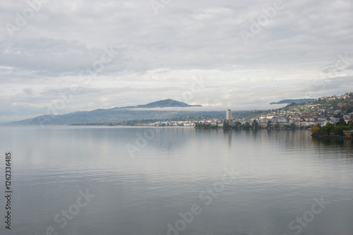 lac avec montagnes en arrière plan et une ville sur la côte