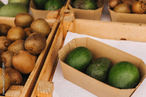 Fresh kiwi and avocado at small local urban market. Organic produce on sale at outdoor farmer market. Selling fresh crops and veggies harvest. European urban setting. Part of the series.
