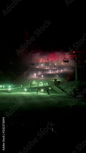 Es un espectaculo de luces que bajan en la montaña con sus distintos colores. Preparando Cortina Italia 2026 en una pista de esquí para esquiar y hacer snowboard.