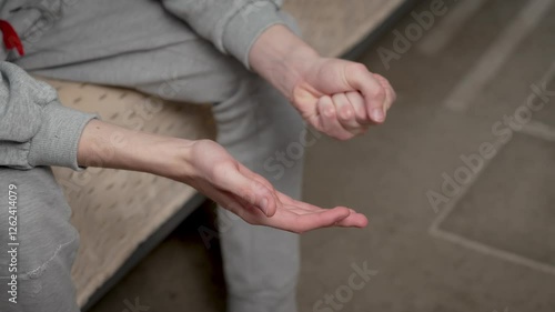 Close up teenage boy hands clenching and unclenching fists. Detailed shot young boy hands making fists and releasing them. Unrecognizable teenager tightening and relaxing fists photo