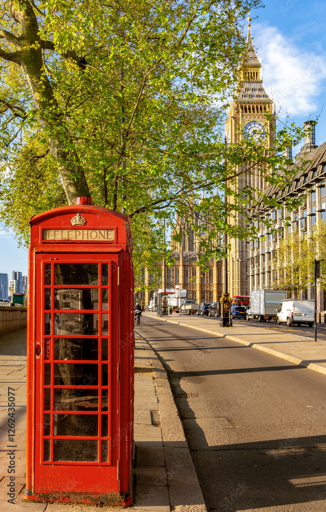 Red telephone box on Victoria embankment with Big Ben at background, London, UK