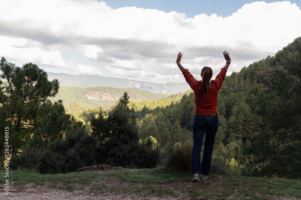 Woman with raised arms enjoying nature in the mountains Woman with raised arms enjoying nature in the mountains